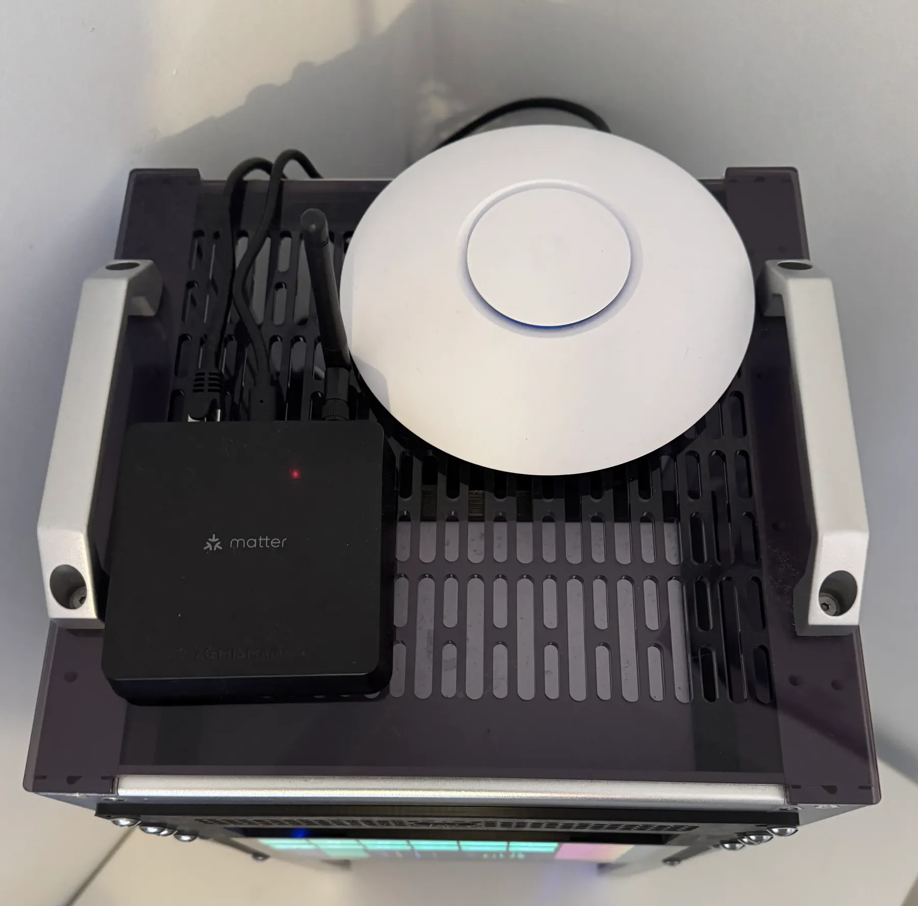Vue du dessus de la baie home lab avec borne UniFi nanoHD, hub Matter Zemismart et equipements IoT.